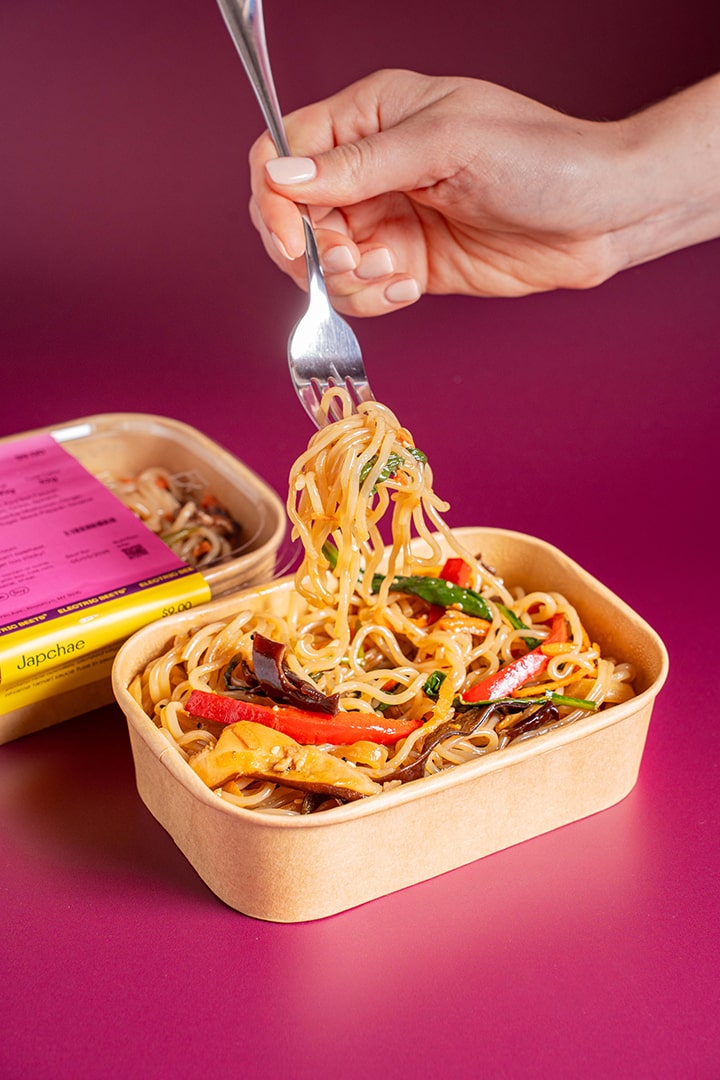 Japchae; Noodles; Sweet Potato Rice Noodles, Red Bell Pepper, Carrots, Shiitake Mushroom, Onion, Spinach, Scallion, Sesame Oil, Wood Ear Mushroom, Ginger, Tamari, Coconut Palm Sugar, Black Pepper, Sesame Seeds; Contains Sesame, Soy; Sweet potato rice noodles, sautéed veggies, and a light sesame tamari sauce come together in savory satisfaction!